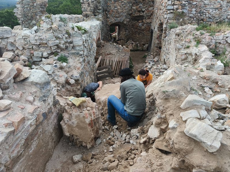 Študenti pri začisťovaní kamenných blokov na Oponickom hrade, Zdroj: KPÚ Nitra (Foto: P. Sater)
